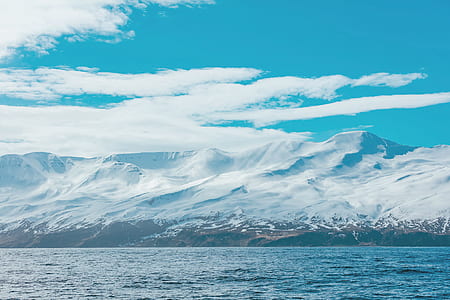 snow covered mountain near ocean thumbnail