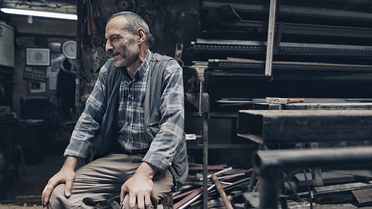 man sitting beside bar cutter machine thumbnail