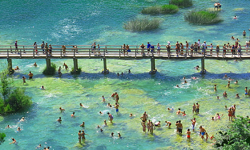 photo of people on body of water and bridge thumbnail