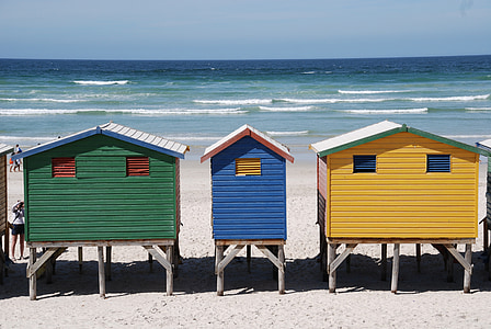 three yellow, blue, and green shed standing near shoreline thumbnail