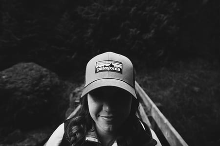 woman wearing dad hat beside fence thumbnail