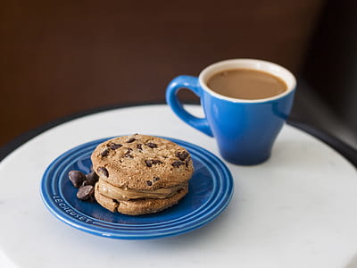 cookies on blue ceramic saucer beside coffee cup thumbnail