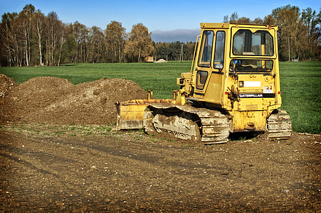 yellow bulldozer beside grass field thumbnail