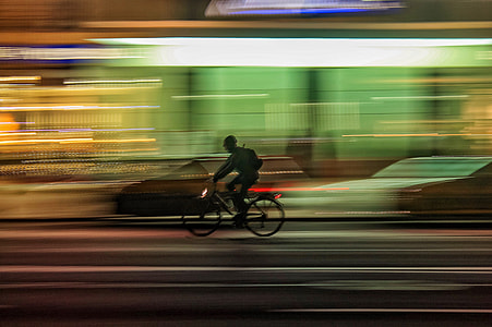 time lapse photo of person riding bike on street thumbnail