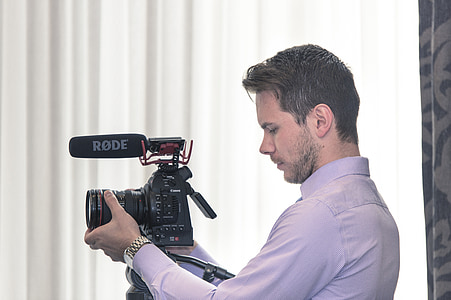 man holding black Rode DSLR camera thumbnail
