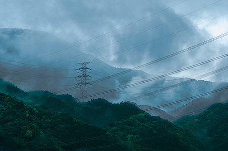 black electricity post at mountain under cloudy sky thumbnail