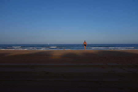 person walking on shore during daytime thumbnail