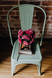 Industrial metal chair with a bouquet of pink flowers and books on it thumbnail