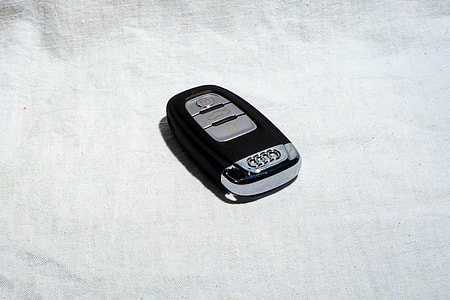 black and gray Audi vehicle fob on white textile thumbnail