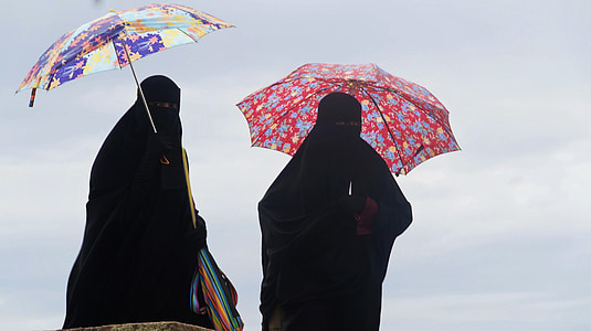 two person standing holding umbrellas thumbnail