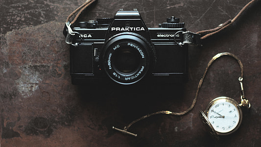 black Praktika bridge camera near gold pocket watch thumbnail
