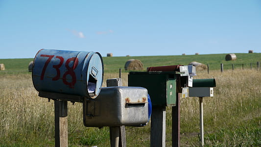 five assorted-color mailboxes on field thumbnail