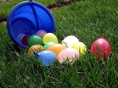 assorted colored water balloons on green grass at daytime thumbnail