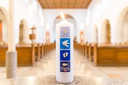 white pillar candle on gray table thumbnail