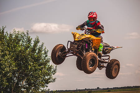 person on yellow and black ATV quad bike during daytime thumbnail
