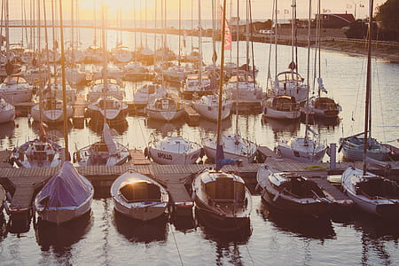 Brown Wooden Board Walk Beside Sailing Boats in Body of Water during Day Time thumbnail