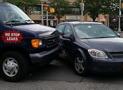 grey sedan hit by blue Ford E-series on road near buildings and trees thumbnail