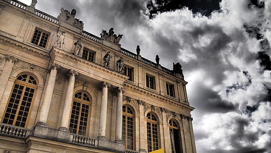 beige concrete building under cloudy skies thumbnail