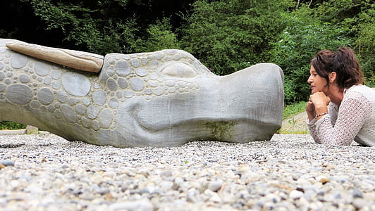 woman staring concrete dragon head statue thumbnail