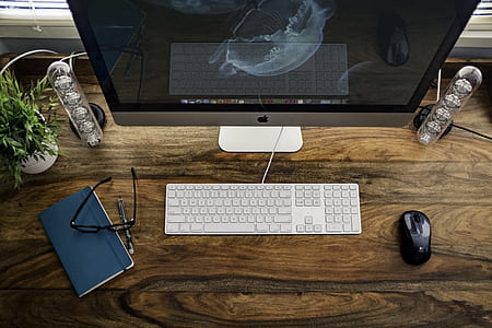 silver iMac on brown wooden table thumbnail
