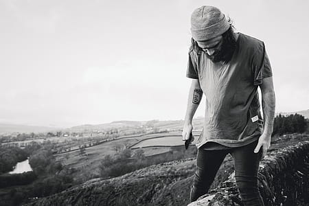grayscale photography of man standing on farm field thumbnail
