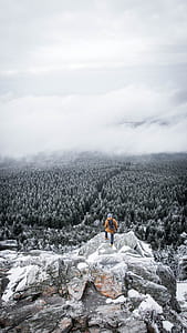 person standing on the cliff on stone thumbnail