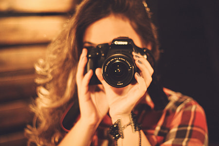 Woman photographer with long hair using a camera thumbnail