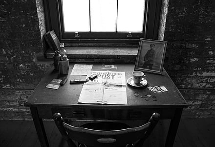 graycale photography of desk and chair beside window thumbnail