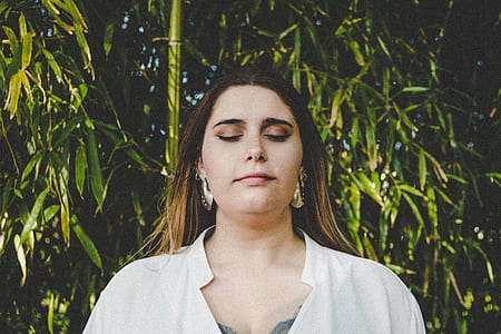 woman standing beside tree thumbnail