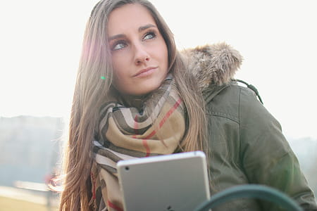 Nice girl looks around and has a tablet in hand thumbnail