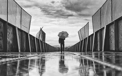grayscale photo of person holding umbrella thumbnail