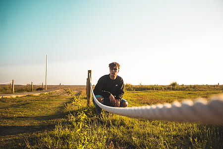 man sitting beside white rope thumbnail