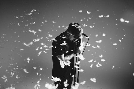 grayscale photography of man holding microphone thumbnail