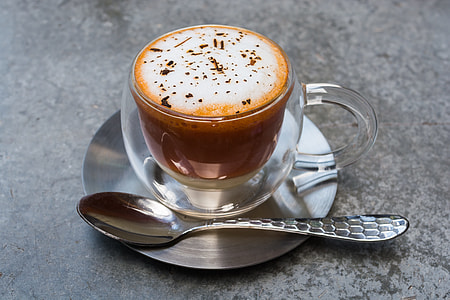 coffee latte with mug, saucer and tea spoon on gray concrete surface thumbnail