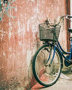 blue city bicycle leaning on wall thumbnail