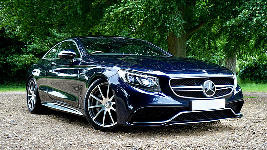 blue Mercedes-Benz coupe parked on dirt road near tree thumbnail