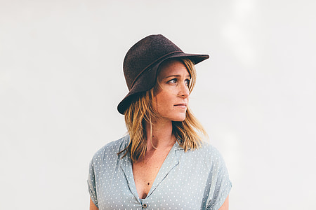 photo of woman wearing black bucket hat and beige v-neck top with white background thumbnail
