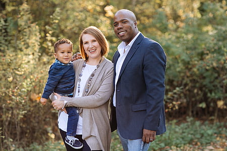 man, woman, and boy smiling while taking their photo thumbnail