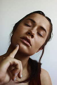 woman pointing her chin beside wall thumbnail