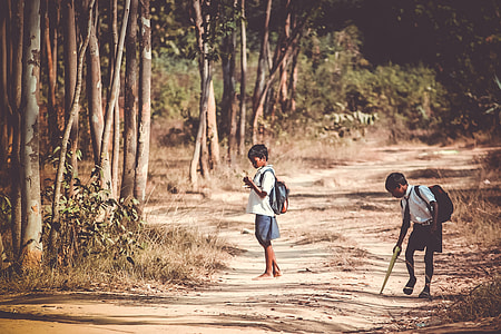 two boys standing near trees at daytime thumbnail