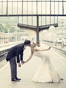 newly wed kissing on train station thumbnail