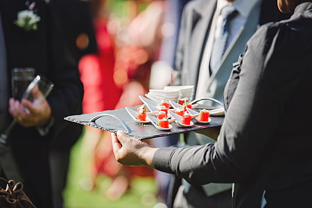 woman wearing black suit jacket holding black tray thumbnail