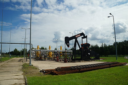 black oil rig on green field landscape photography thumbnail