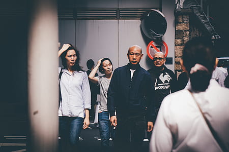 man wearing black long-sleeved shirt standing nearby several peoples thumbnail
