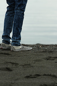 person wearing blue pants standing near body of water thumbnail