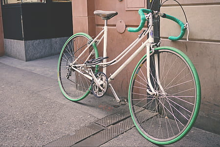 White and Green Bike Leaning on Wall thumbnail