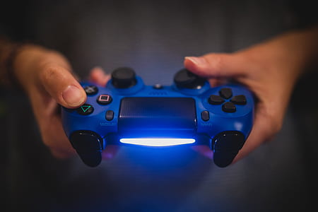 person holding blue Sony DualShock 4 thumbnail