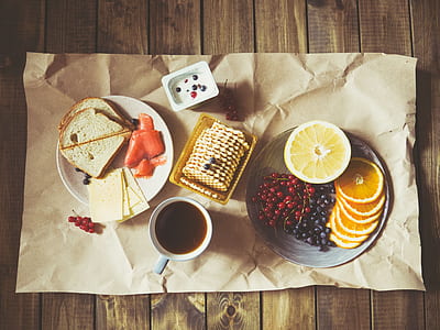 white ceramic mug filled beside white plate and biscuit tray on brown surface thumbnail