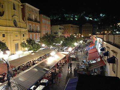 people gathering near buildings and trees at night time thumbnail