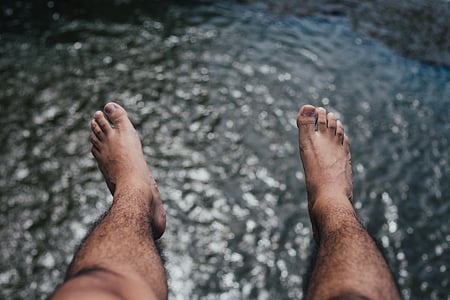 man's feet above body of water thumbnail
